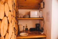 a kitchen with a sink and a microwave on a shelf at Pousada Aberdeen in Campos do Jordão