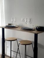 a table with two stools and wine glasses on it at Bleu Suprême balnéo in Vierzon