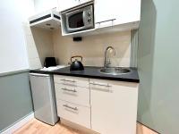 a small kitchen with a sink and a microwave at Loft Vincennes in Vincennes