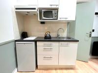 a small kitchen with a sink and a microwave at Loft Vincennes in Vincennes
