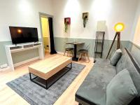 a living room with a couch and a flat screen tv at Loft Vincennes in Vincennes