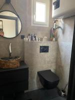 a bathroom with a black toilet and a sink at Appartement vue Tour Eiffel paris 16 Eme in Paris