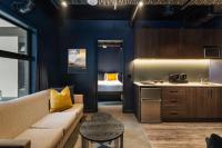 a living room with a couch and a kitchen at Abstract Hotel in Auckland