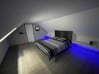 a bedroom with a bed with blue lights in it at Appartement Amiens-Camon in Camon