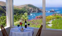 einen Tisch mit einer Flasche Wein und Meerblick in der Unterkunft SCP Mendocino Coast Lodge in Albion