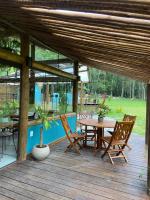 una terraza de madera con mesa y sillas en Matha Pousada e Bistrô, en Lumiar