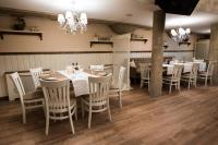 une salle à manger avec tables et chaises et un lustre dans l'établissement Hotel Victoria, à Panagyurishte