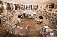 un escalier dans un restaurant avec un lustre dans l'établissement Hotel Victoria, à Panagyurishte