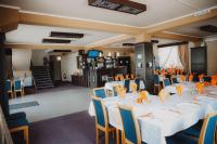 Un salón de banquetes con mesas blancas y sillas azules. en MOTEL POPAS TALMACIU, en Tălmaciu