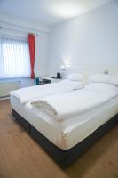 a large white bed in a room with a red curtain at AP Hotel Mannheim Viernheim am Kapellenberg in Viernheim