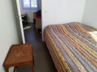 a bedroom with a bed and a table next to a door at Appartement de 2 chambres avec vue sur la ville terrasse amenagee et wifi a Saint Ouen in Saint-Ouen