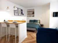 a small apartment with a bed and a table and chairs at Cosy &amp; Chic - Hyper centre - Wifi - Proche gare in Châteauroux