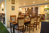 uma sala de jantar com mesas e cadeiras de madeira em Hotel Citrus Prime Candolm, Goa em Candolim