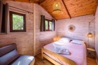 a bedroom with a bed in a wooden cabin at Camping U Pirellu in Porto-Vecchio