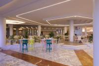 a lobby with tables with colorful stools at Calimera Blend Paradise in Hurghada