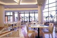 a dining room with tables and chairs and windows at Calimera Blend Paradise in Hurghada