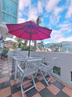 a table and chairs with a red umbrella on a patio at White Palace B&amp;B in Ji&#39;an