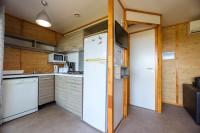 a white refrigerator in a kitchen with wooden walls at Camping U Pirellu in Porto-Vecchio