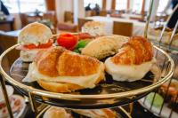 圣地亚哥-德尔埃斯特罗HT Hotel Deluxe Resort & SPA的桌上有一盘三明治和羊角面包