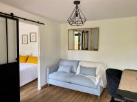 a bedroom with a couch and a bed and a mirror at Magnifique appartement 2&#47;4 pers - Le Saint Leo in Saint-Léonard-des-Bois
