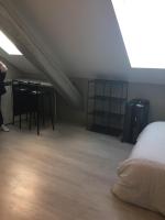 a attic room with a bed and a table and chairs at Studio étage 3, proche Techn&#39;hom, IUT et UTBM in Belfort