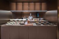 Um chef em uma cozinha com alguns alimentos sobre a bancada. em Crystal Orange Hotel - Shenzhen Nanshan Xinhaofang Branch em Shenzhen