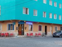 a building with red tables and chairs in front of it at OKEANOS in Sal Rei