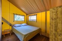 a small bedroom with a bed in a yellow room at Camping U Pirellu in Porto-Vecchio