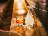 a bottle and a glass of drink on a table at The Playford Adelaide - MGallery in Adelaide