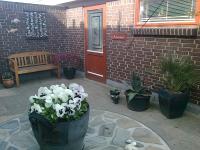 Un patio con plantas en macetas frente a un edificio. en Anneks Bågøvej, en Skagen