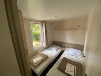 a small room with two beds and a window at MOBIL HOME Clim BOOFZHEIM 6 PERSONNES 3 CHAMBRES LE RIED 3 ETOILES PROCHE EUROPA PARK in Boofzheim