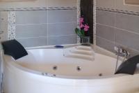 a white bath tub with a vase of pink flowers at Villa Provence Vue Panoramique - in Fayence