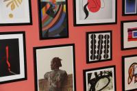 a wall full of framed art on a red wall at FINESTATE Coliving Champs-Elysées in Paris
