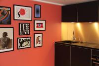 a kitchen with an orange wall with pictures on it at FINESTATE Coliving Champs-Elysées in Paris