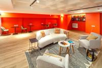 a living room with white furniture and red walls at FINESTATE Coliving Champs-Elysées in Paris