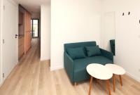 a living room with a green couch and a table at FINESTATE Coliving Champs-Elysées in Paris