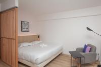 a bedroom with a bed and a chair at FINESTATE Coliving Champs-Elysées in Paris