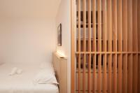 a bedroom with a wooden partition next to a bed at FINESTATE Coliving Champs-Elysées in Paris