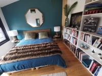 a bedroom with a bed and a book shelf with books at Standing, calm &amp; confort. in Bègles