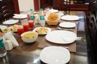a table with white plates of food and drinks at Wayanad Mace Mansion in Kenichira