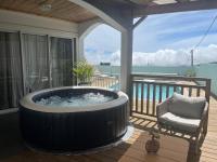 a hot tub on the deck of a house at Villa Bois Court 3 chambres in Le Tampon