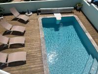 an overhead view of a swimming pool with chairs on a deck at Villa Bois Court 3 chambres in Le Tampon