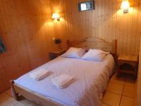 a bedroom with a bed with two towels on it at Chalet Beaujon Chapelle-des-Bois in Chapelle-des-Bois