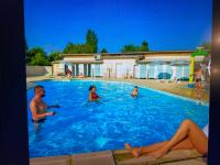a group of people in a swimming pool at MOBIL HOME Clim BOOFZHEIM 6 PERSONNES 3 CHAMBRES LE RIED 3 ETOILES PROCHE EUROPA PARK in Boofzheim