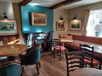 a restaurant with a fireplace and a table and chairs at The Lower Buck Inn in Clitheroe