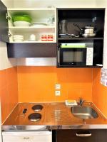 a kitchen with a sink and a microwave at ApartHotel Sainte-Marthe in Avignon