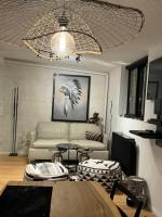 a living room with a couch and a chandelier at Appartement vue Tour Eiffel paris 16 Eme in Paris