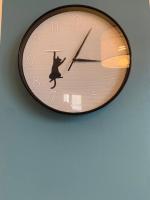 a clock hanging on a wall with a person dancing at Etape saumuroise en centre-ville in Saumur