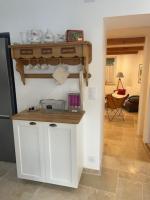a kitchen with white cabinets and a shelf on the wall at Gite sur la Founintrouze in Fabrezan
