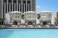 Una piscina con sillas y sombrillas al lado de un edificio. en Le Meridien New Orleans, en Nueva Orleans